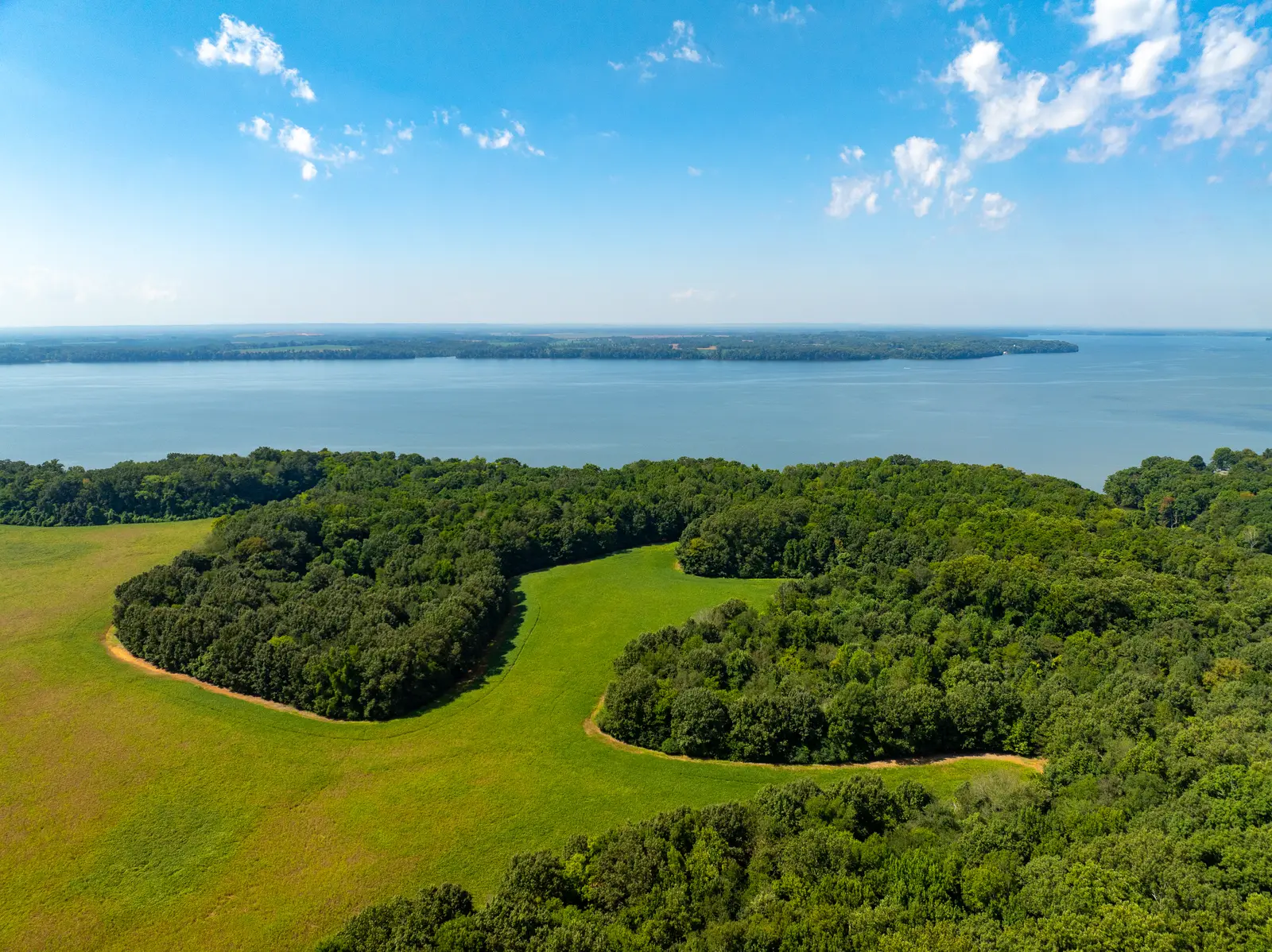 Open pasture and tree islands with Lake Wheeler beyond